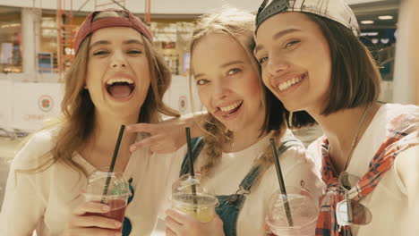 three friends enjoying drinks at the mall