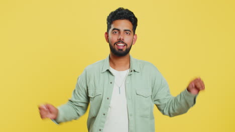 Happy-young-Indian-man-listening-music-dancing-disco-having-fun-relaxing-on-party-making-funny-moves