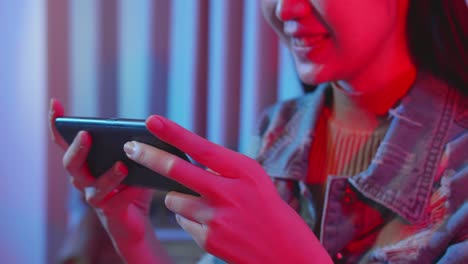 asian girl playing video game online on mobile phone