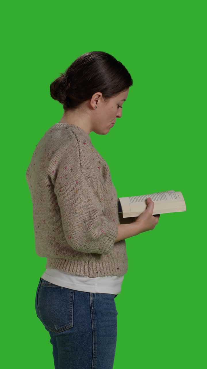 Video verticale: profilo di giovane che legge un libro d'azione in studio