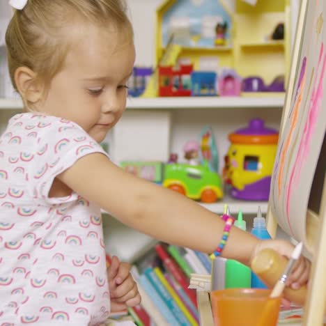 little girl having fun painting with water colors