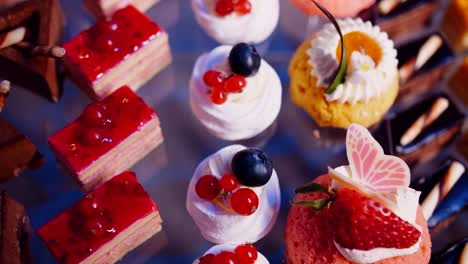 small cakes and desserts on glass table, top down view