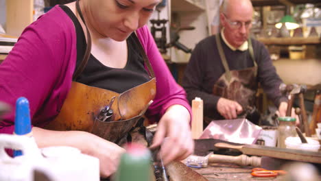 bespoke shoemaker pinning leather together to make shoe