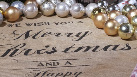 close tilt of christmas decorations and greeting text on table cloth