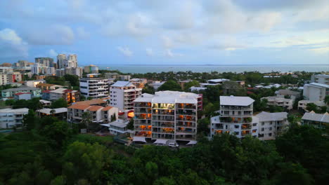 coastal cityscape at twilight with modern buildings and lush greenery
