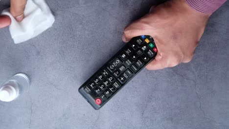 limpieza de un control remoto de la televisión con toallas desinfectantes