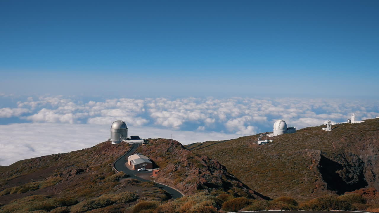 vista panorámica con nubes en el fondo, del observatorio roque de los muchachos ubicado en el parque nacional caldera de taburiente, en la isla de la palma y en un día soleado