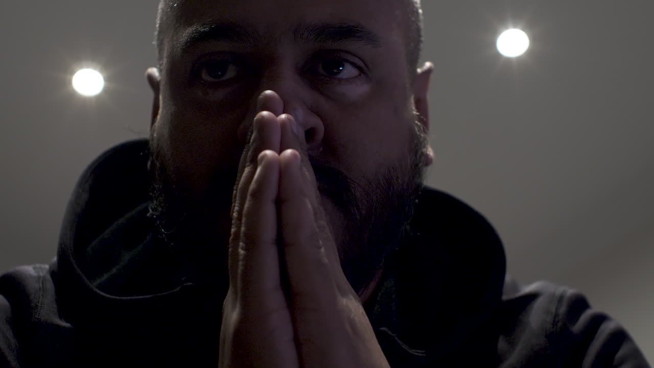 vista de ángulo bajo del hombre indio con las manos entrelazadas balanceándose hacia adelante y hacia atrás