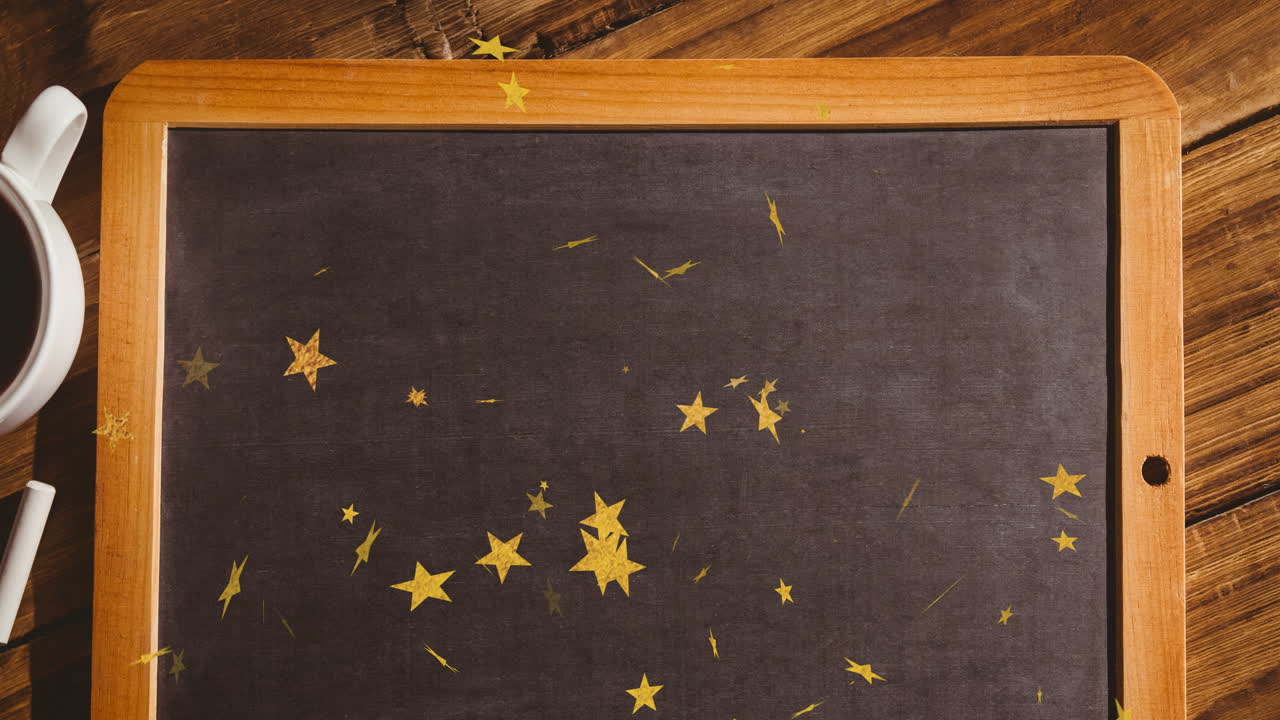 Golden stars scattered on blackboard with wooden frame on wooden school desk
