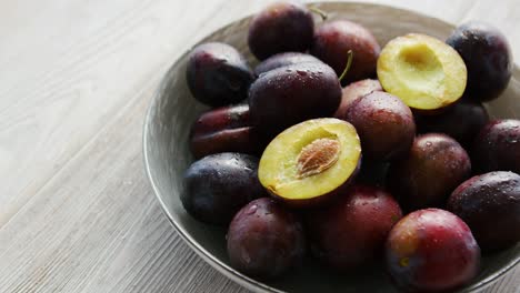 Bowl-of-fresh-plums-in-daylight