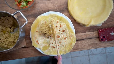 Draufsicht-Auf-Eine-Frau,-Die-Fleisch-Auf-Ein-Stück-Tortilla-Legt