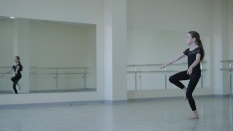 young ballerina practicing dance moves in studio