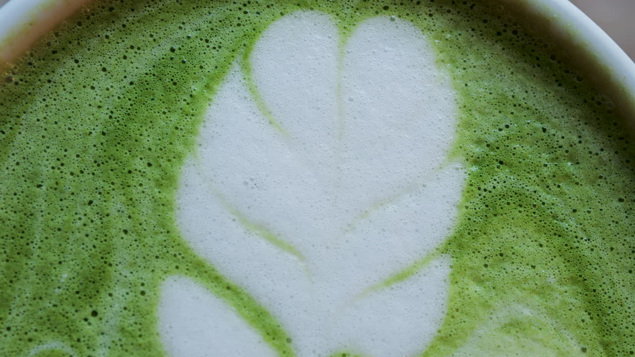 Close up of a matcha latte on a wooden table