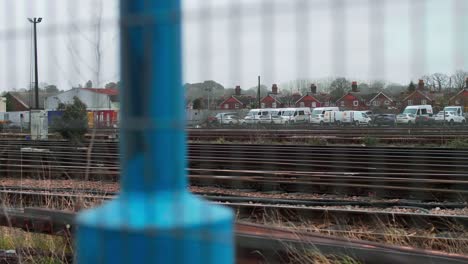 rusty train tracks with car park in distance