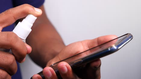 cleaning a mobile phone with hand sanitizer