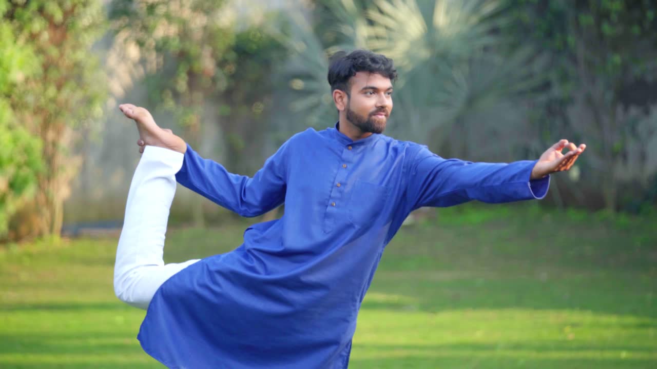 Uomo indiano che esegue la posizione yoga del Signore della Danza