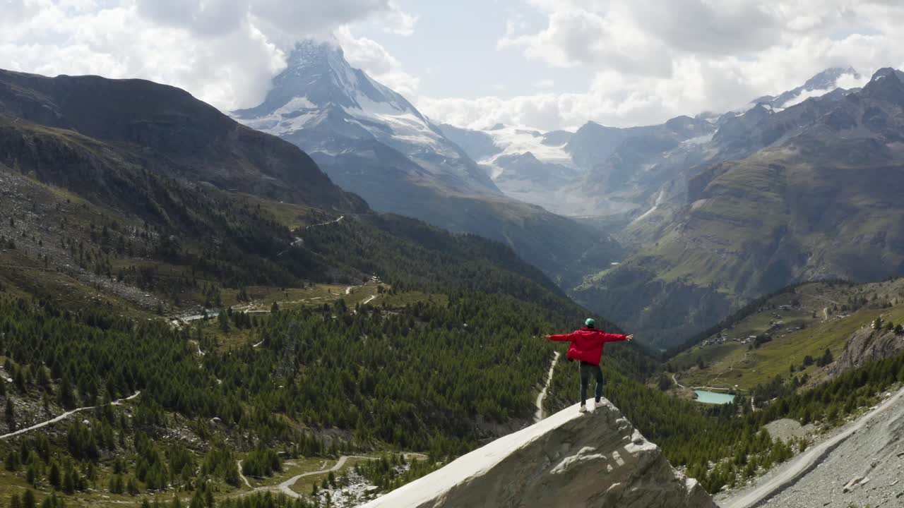 antena pasa a un joven excursionista con una vista épica sobre el matterhorn, zermatt, suiza