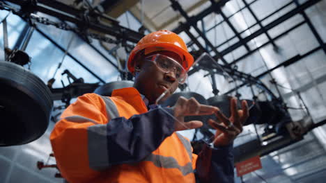 focused engineer tapping glass tablet at huge manufacturing factory closeup