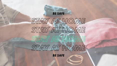 animation of words be safe stay at home flashing over a person sewing coronavirus covid19 masks