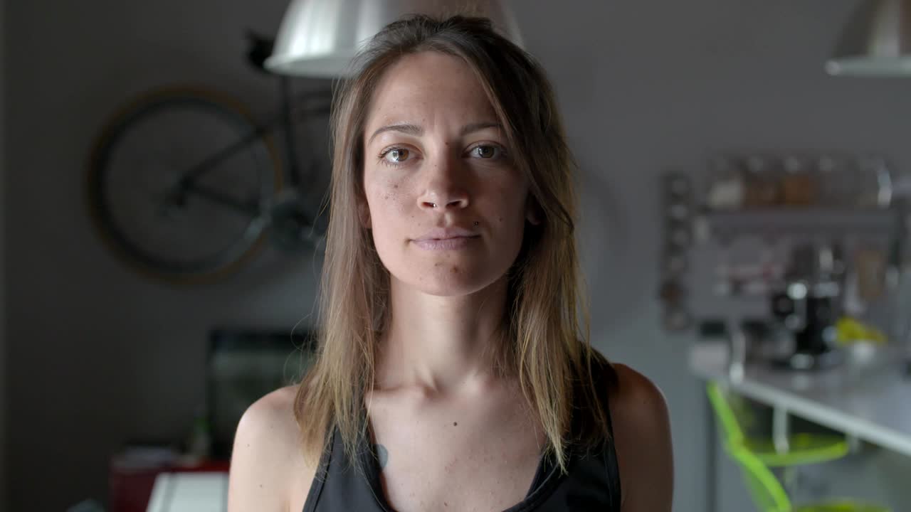 joven tatuada relajada mujer deportiva retrato en casa..sala de estar entrenamiento doméstico. video en cámara lenta 4k