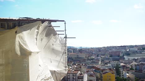 building under construction in lisbon, with city view in background