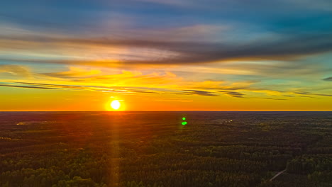 golden sun shining over the dense forest at dusk. - timelapse shot