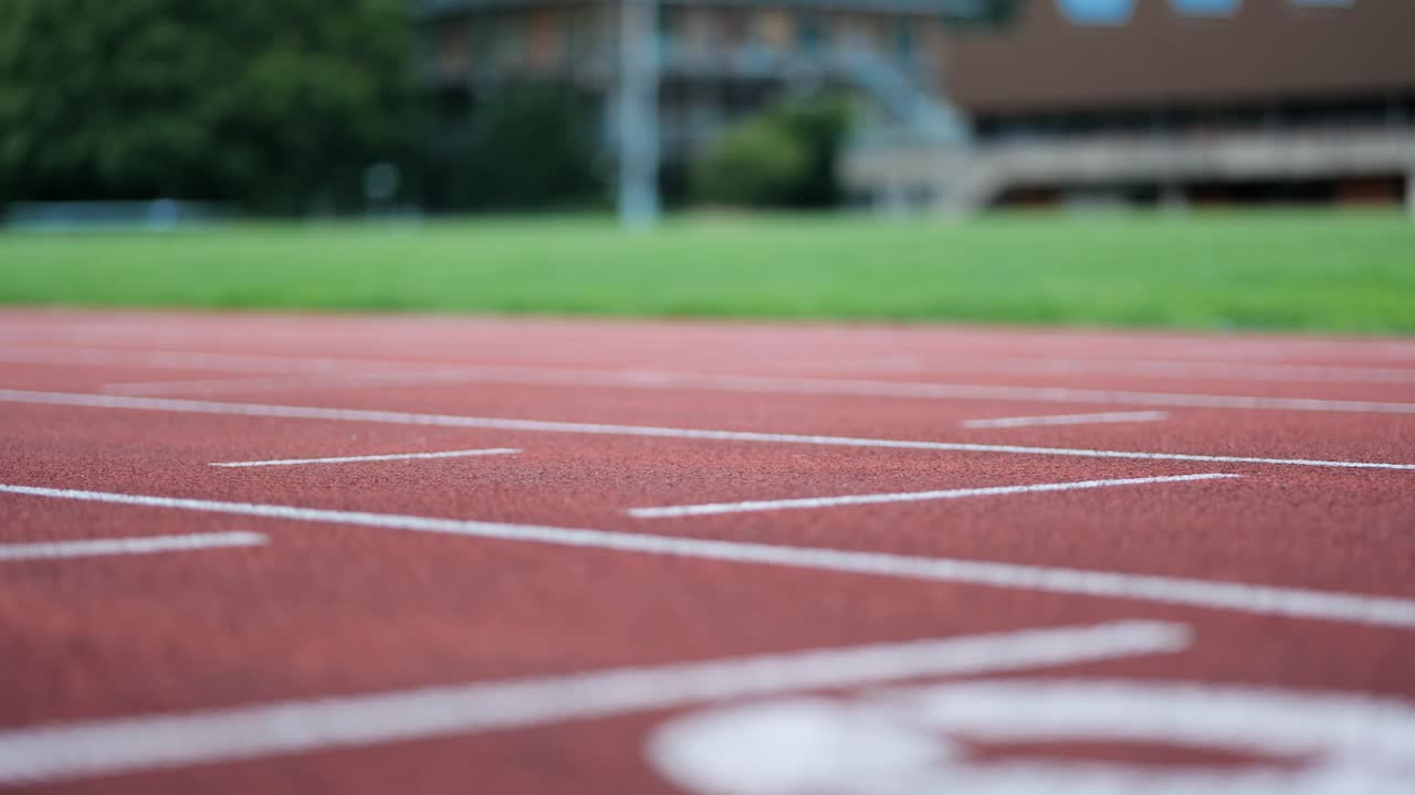Detailní sledovací záběr běžecké dráhy s tréninkem běžce