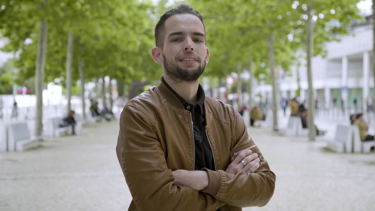 hombre barbudo y guapo posando con los brazos cruzados.