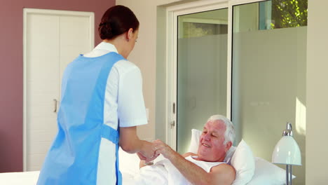 nurse giving pills to senior man