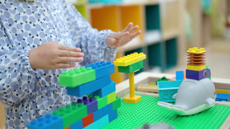 Niña-Pequeña-Jugando-Con-Construcción-De-Ladrillos-De-Plástico-Entrelazados-Lego