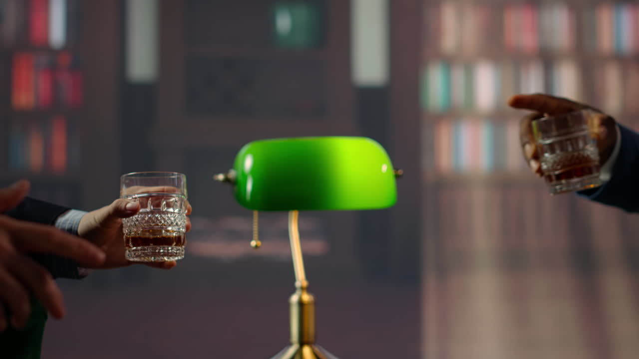 miembros de la élite de clase alta de la sociedad sonando copas de whisky para un brindis