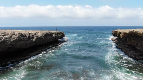 Turistas-Observando-Olas-Rompiendo-En-Acantilados-Escarpados-En-El-Parque-Nacional-Shete-Boka,-Curazao,-Amplia-Vista-Aérea