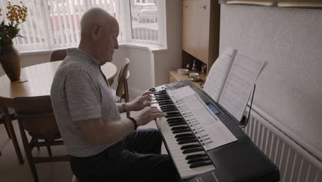 elderly man playing piano at home