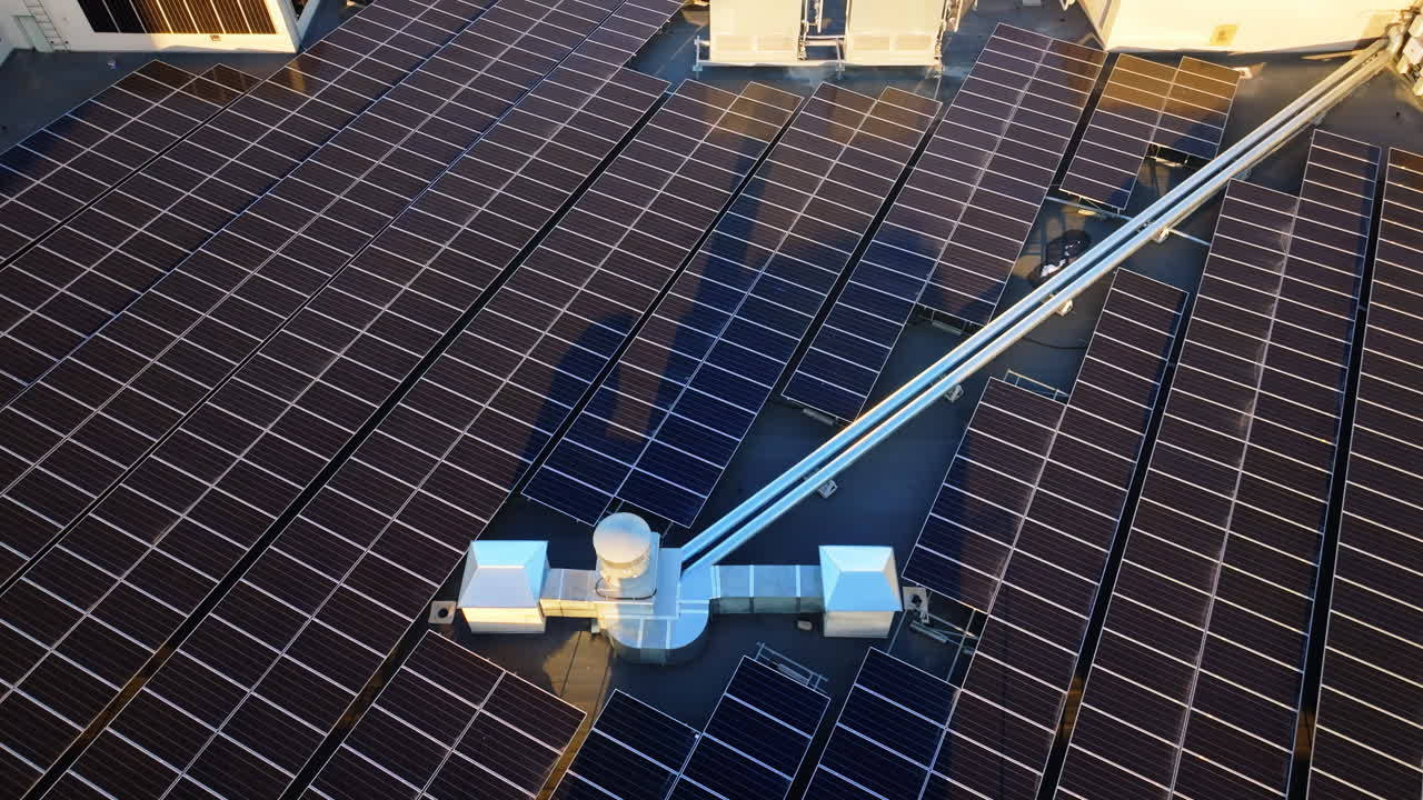 Aerial drone view of solar panels at sunset. Photovoltaics on top of the roof of the building. Alternative electricity source. Concept of sustainable resources