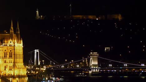 Budapest-city-center-view-with-illuminated-Erzsébet-Bridge-and-Danube-river-at-night,-gothic-architecture,-light-reflections,-distant-medium-shot