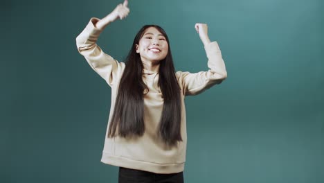 a young asian lady is dancing delightfully in slow motion