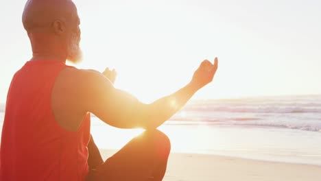 senior african american man practising yoga at the beach