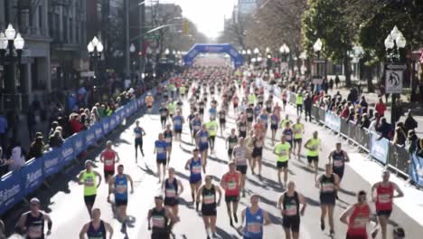an aerial view of marathon participants racing through city streets with spectators cheering and a colorful atmosphere in a vibrant urban setting