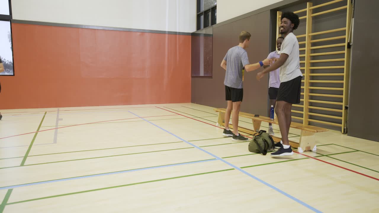 Mangfoldig herrelag samles i treningsstudioet etter at en spiller går med volleyball, forbereder seg, med plass til tekst