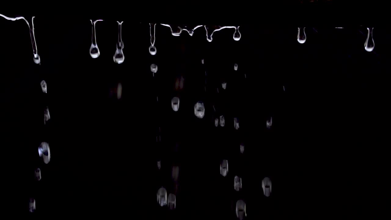 Dripping water (rain) on black background, Slow motion (120 FPS).