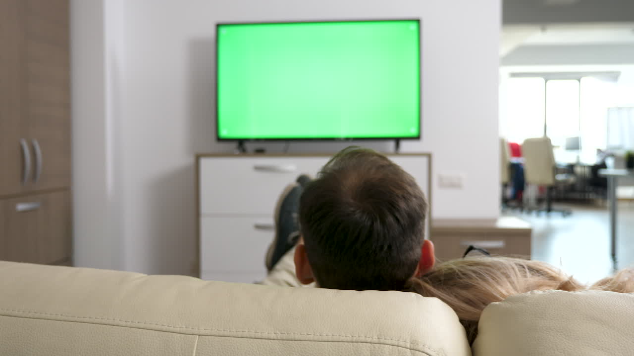 Coppia guardando la televisione a casa