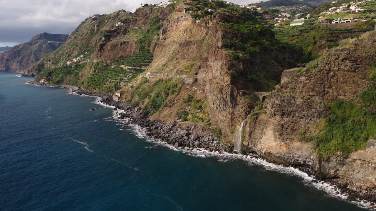 Veduta aerea di suggestive scogliere costiere con cascata che sfocia nell'oceano