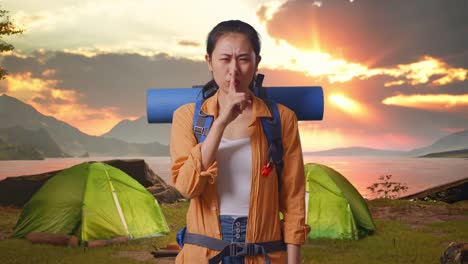 woman camping at sunset, asking for silence