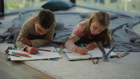 hermano y hermana dibujando con lápices de colores