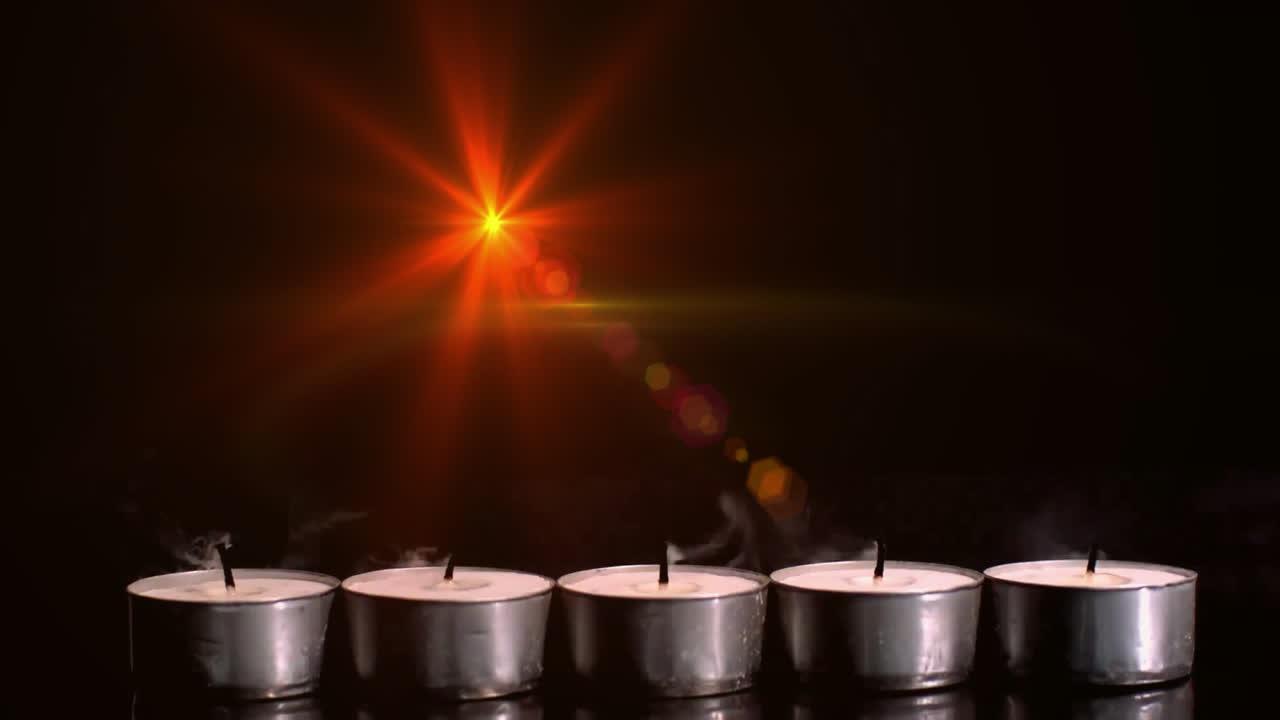 Burning candles animation over extinguished tealight candles in dark background
