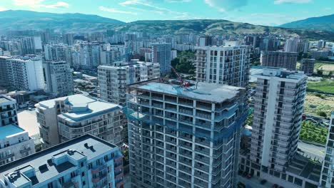 An-aerial-view-of-a-city-blanketed-in-snow,-with-high-rise-buildings-and-streets-covered-in-white,-capturing-the-serene-beauty-of-an-urban-winter-landscape