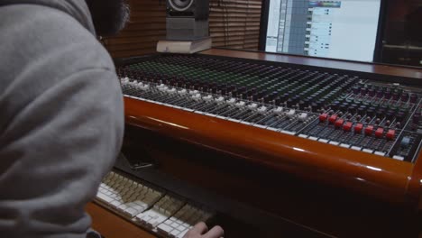 man in a control room of a recording studio making a mix with a toft console - professional recording studio - 4k at 60fps (slowmotion) - professional audio vives