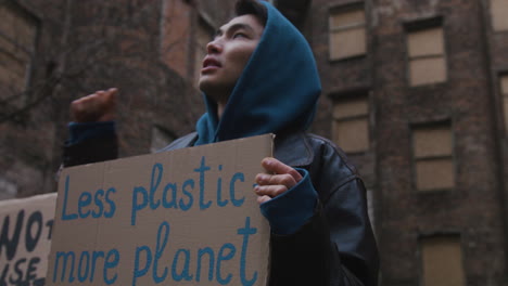 vista inferior de activistas levantando puños durante una protesta por el cambio climático en la calle 1