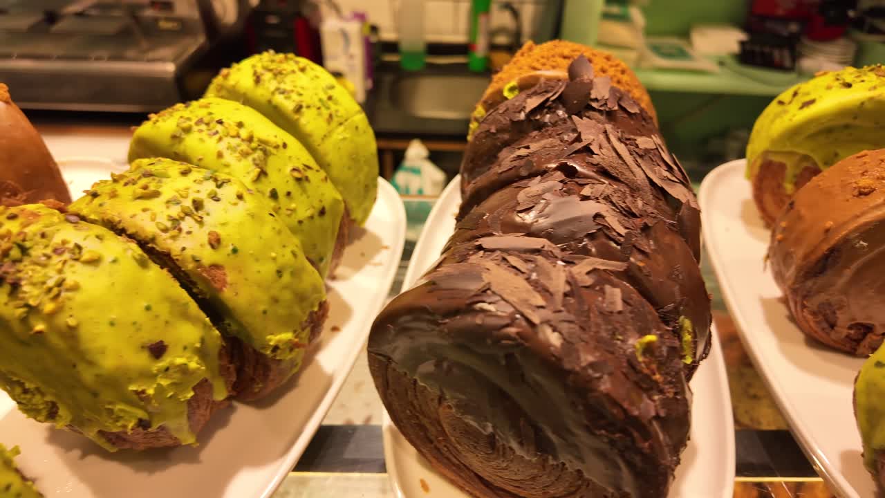 Deliciosos pasteles con glaseado de chocolate y pistacho en exhibición
