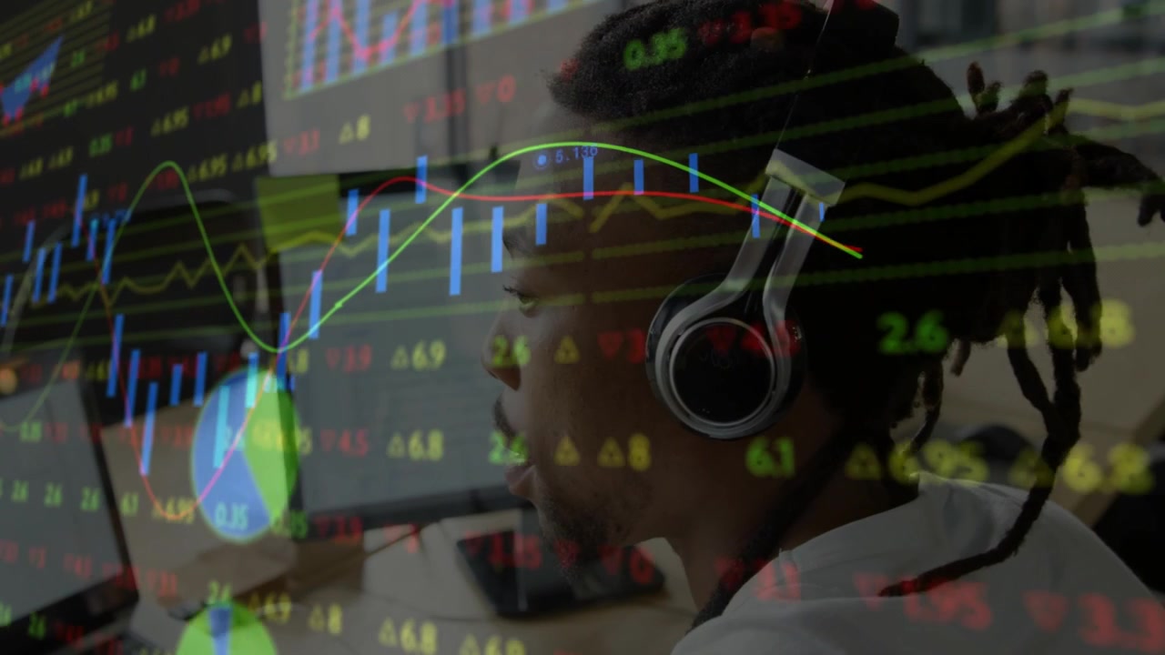 Afroamerikansk mann med hodetelefoner analyserer finansdata på datamaskin